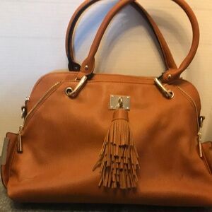 Tan purse with tassel trim and zipper accents